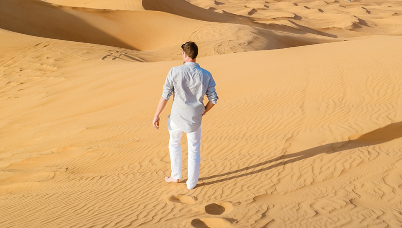 Homem andando no deserto